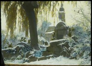 Langenhennersdorf, Dorfkirche. Blick über die Friedhofsmauer zur Kirche. Winteraufnahme