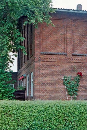 Seefeld 31: traufständiges Bauernhaus aus Backstein: Teilansicht: Giebelseite und Straßenfront Wohntrakt, in Obergeschoss Blindfenster: Gartenhecke