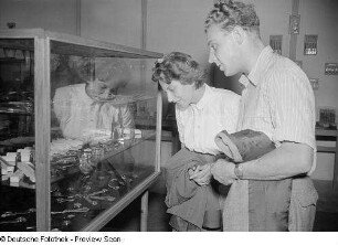 Fachbesucher vor einer Ausstellungsvitrine mit Armbanduhren