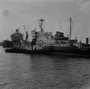 Rostock. Überseehafen, Schiff mit Schlepper