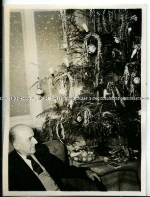Älterer Mann neben einem Weihnachtsbaum
