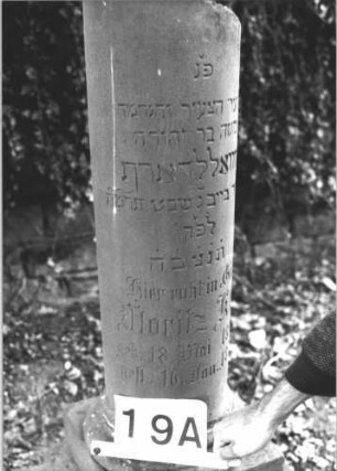 Grabstein 19 (Index: 99808376) Material: Sandstein Zustand: gut, Säulenbasis leicht verwittert Maße HxBxT: 105x40x40 cm Beschreibung: Säulenstumpf, getreppter Sockel Besonderheit: Kindergrab: Grabstein 19A (1)