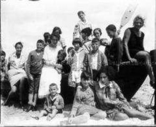 Kindergruppe mit Erzieherinnen im Boot am Strand