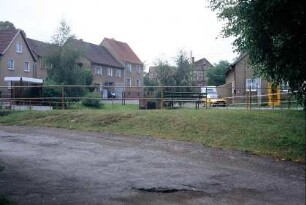 Blick über den Dorfteich auf Häuser der 1960er Jahre; links Buswartehalle