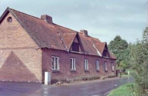 Alte Dorfstraße 9: ehemalige Gutsarbeiterkate, Mehrfamilienkate aus Backstein: traufständige Straßenfront: zwei Zwerchgiebel mit Luken: links Giebelseite