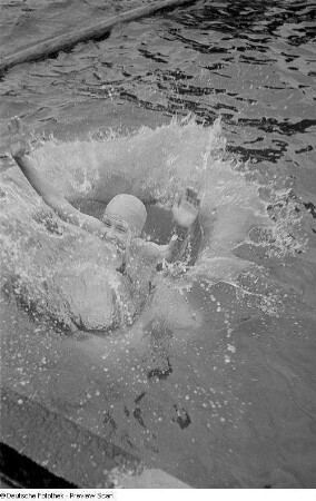 Mädchen beim Sprung ins Schwimmbecken eines Freibades