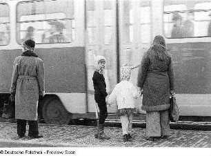 Kostümierte Kinder an einer Straßenbahnhaltestelle
