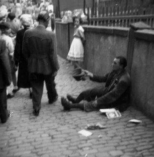 Schlitz. Trachtenfest. Bettler, an einer Mauer sitzend