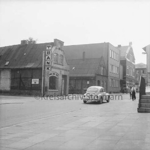 Hagenstraße: hinten links Firmenschild der Volksbank Bad Oldesloe vor Haus: rechts VW-Käfer und Fußgänger: hinten rechts Stadthaus und Altbau der Kreissparkasse Stormarn: 15. Mai 1975