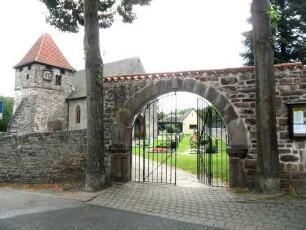 Eichel-Ansicht von Nordwesten mit Kirche (Romanisch) über Kirchhofmauer (Wehrgang im 19 Jh abgetragen) sowie erhaltenem äußerem Torbogen des einstigen Kammertors (romanischer Rundbogen auf Kampfer)