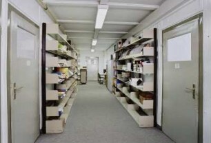 Sächsische Landesbibliothek - Staats- und Universitätsbibliothek Dresden. Zweigbibliothek Wirtschaftswissenschaften. Baracke 19/20. Gang der Baracke 19 mit Regalen im Dienstbereich