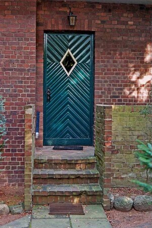 Sieker Landstraße 161: Wohnhaus aus Backstein, mit Zeltdach: Teilansicht: Eingangstür, davor Treppe