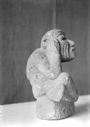 Steinfigur eines alten, schwerhörigen und buckligen alten Mannes