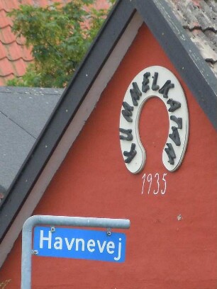 Snogebaek - Hausgiebel : Vor einem roten Hausgiebel steht das Straßenschild. Aufgenommen am 6. August im Fischerort Snogebaek auf der dänischen Ostseeinsel Bornholm