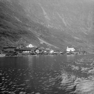 Norwegen. Fjordlandschaft. Blick zum Ufer mit einer Siedlung mit Kirche