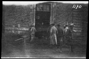 Cambrai (Dep. Nord, Frankreich): Soldaten und (einheimische?) Zivilisten vor dem Eingangstor zu einem Gebäude ("Engländer im Lager von Cambrai, Flieger")