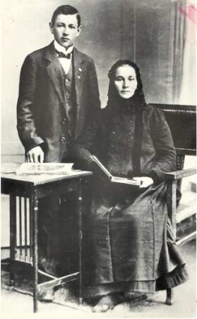"Polnische" Kirchgangstracht aus Nochten : Kleidung - Truhentracht. Ort: Wochozy / Nochten. "Polnische" Kirchgangstracht ("halbdeutsch"), Chenilletuch, schwarzer Rock, Sackjacke, schwarze Schürze. Maria Petrick aus Nochten im Jahre 1917 mit ihrem Sohn.