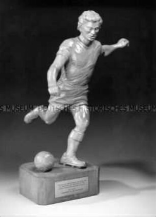 Holzskulptur eines Fußballspielers