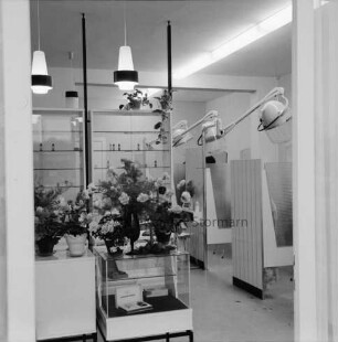 Salon Ute: Hamburger Straße: Friseursalon: Inhaberin Ute Subjetzki: Eröffnung: Innenaufnahme, Blick durch Fenster: Verkaufstheke, darauf Blumen: hinten rechts Kabinen mit Trockenhauben