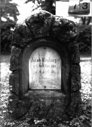Grabstein 73 (Index: 100101528) Material: Kalkstein, weiße Marmorplatte Zustand: gut Maße HxBxT: 92x53x30 cm Beschreibung: Stele, rustica, Schriftplatte mit Rundbogenabschluß: Grabstein 73