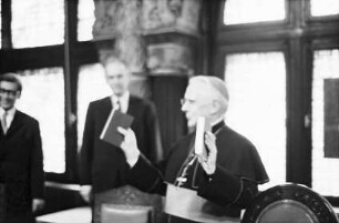 Freiburg: Erzbischöfliches Ordinariat, Dr. Herder übergibt Erzbischof Dr. Schäufele [neues] Gesamt-Gesangbuch [Gotteslob]