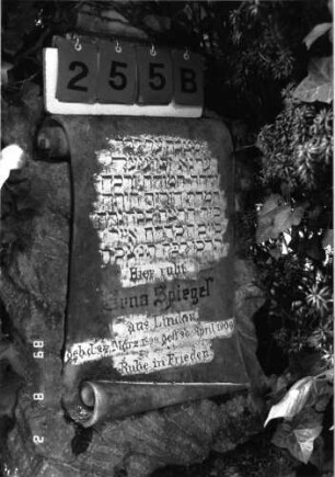 Grabstein 255 (Index: 100102007) Material: Kalkstein, weißer Marmor bei Aufsatz und Schriftplatte Zustand: leicht verwittert Maße HxBxT: 169x56x48 cm Beschreibung: Postament mit Urnenaufsatz auf Sockel, Schriftplatte in Pergamentrollenform Symbolik: Urnenaufsatz Besonderheit: Kindergrab: Grabstein 255B