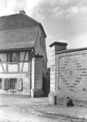 Steinkreuz : Hirschfelde, Steinkreuz (D 251) an der äußeren Kirchhofsmauer der Pfarrkirche St. Peter und Paul nahe dem Eingang