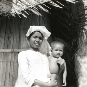 Calicut, Indien. Junge Inderin mit Kleinkind auf dem Arm