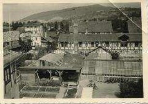 Blick auf die Gewächshausflächen der Deutschen Kolonialschule Witzenhausen mit Remise und Mühle