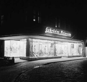 Gebrüder Petersen: Textilhaus: Besttorstraße, Ecke Hude: erleuchtete Schaufenster: darüber Firmenname als Leuchtreklame: im Dunkeln