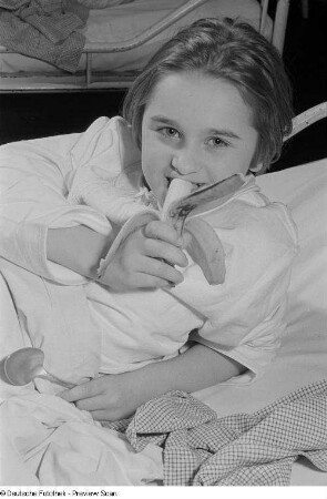 Ein Banane essendes Mädchen im Dr.-Georg-Sacke-Heim