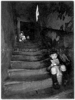 Kleiner Junge auf einer Treppe sitzend (Altersgruppe 18-21)