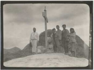 Personen am Gipfelkreuz auf dem Hügel von Nuevo Mundo