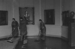 Eröffnung der Dauerausstellung in der Alten Nationalgalerie : Reinigungskräfte vor dem Gemälde "Die Gattin des Künstlers" von Fritz Rhein