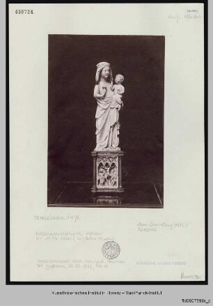 Madonnenstatuette auf einem reliefiertem Sockel mit der Kreuzigung Christi