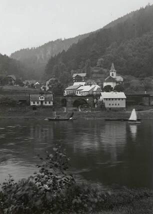 Ortsansicht mit Eisenbahnbrücke und Dorfkirche. Blick über die Elbe