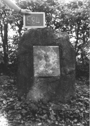 Grabstein 584 (Index: 100111453) Material: Granit, weiße Marmorplatte Zustand: gut, Platte gesprungen, Platte ohne Inschrift Maße HxBxT: 82x55x60 cm Beschreibung: grob stelenhaft behauener Stein, rechteckige Schriftplatte: Grabstein 584
