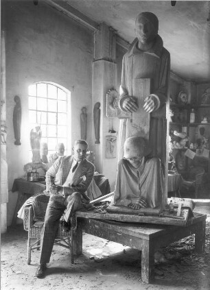 Magdeburger Ehrenmal : Güstrow, Schützenstraße 30. Atelier Ernst Barlachs. Der Bildhauer Bernhard A. Böhmer (Gehilfe Barlachs) mit der Mittelgruppe des Magdeburger Ehrenmals. Eichenholz, geschnitzt (1929; E. Barlach)
