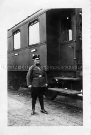Mann in Uniform neben einem Eisenbahnwaggon