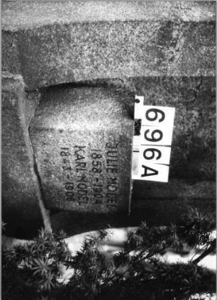 Grabstein 696 (Index: 99630198) Material: Granit Zustand: gebrochen und repariert Maße HxBxT: 225x87x42 cm Beschreibung: St. m. giebelart. Abschl, rechteck. Nische u. begrenzt. Seitenteilen: Grabstein 696A