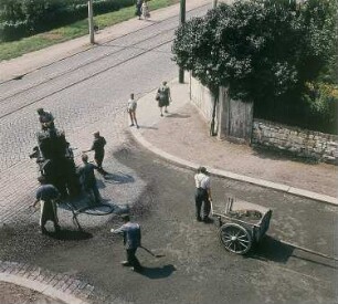 Dresden-Leutewitz. Straßenbauarbeiten Auf der Scheibe Ecke Warthaer Straße, Herstellen einer Einstreudecke (Splitt) auf bituminösen Bindemittel, aufgebracht mit Bitumenspritzmaschine
