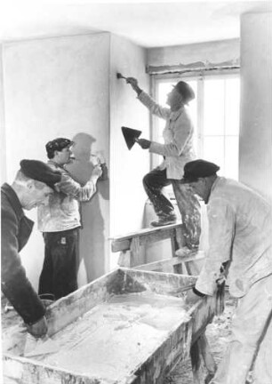 Wohnungsnot macht erfinderisch. Ein ehemaliger Luftschutzbunker aus dem 2. Weltkrieg wird zu Wohnungen umgenutzt. Bauarbeiter verputzen Wände.