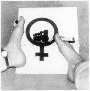 Frau malt mit ihren Füßen ein Symbol (Altersgruppe 18-21)