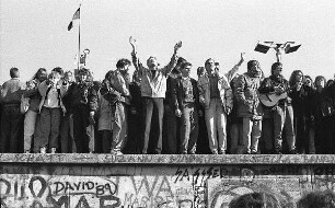 Jubelnde Menschen auf der Berliner Mauer am Brandenburger Tor