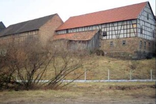 Hang, an dessen Oberkante große Scheunen stehen