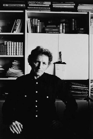Der Schriftsteller Paul Wiens in seinem Arbeitszimmer in Berlin vor einem Bücherregal sitzend