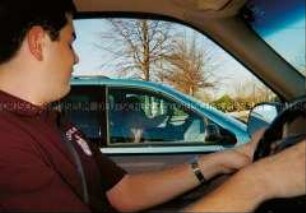 Junger Mann am Steuer eines Autos (Altersgruppe 14-17)