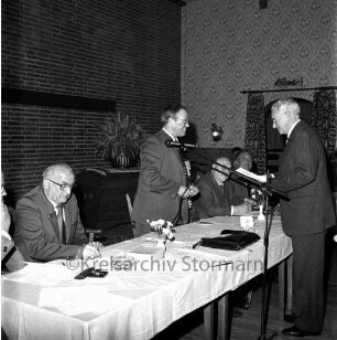 Kreisjägerschaft Stormarn e.V.: Rohlfshagen/Kupfermühle: Gastwirtschaft "Kupfermühle": Saal: Mitgliederversammlung: Podium mit Gremienmitgliedern: Kreisjägerschaftsvorsitzender Hans Bünning im Gespräch