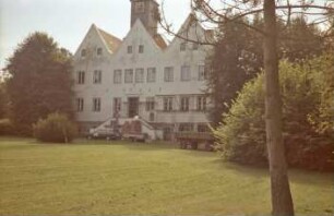 Nütschau: ehemaliges Gut [heute Kloster Nütschau]: Herrenhaus: Renovierung: Nordfassade: vor Eingangsportal und Erdgeschoss rechts Gerüst: vor Freitreppe Gerüstteile: oben Dachreiter mit Uhr: auf Rasen Pkw mit Anhänger