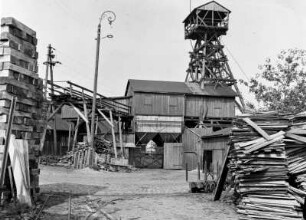 Steinkohlenschacht. Schacht vom 21. Lichtloch. Gruben- und Bauholzstapel gegen Förderturm : Wurgwitz-Niederhermsdorf. Steinkohlenschacht. Schacht vom 21. Lichtloch. Gruben- und Bauholzstapel gegen Förderturm